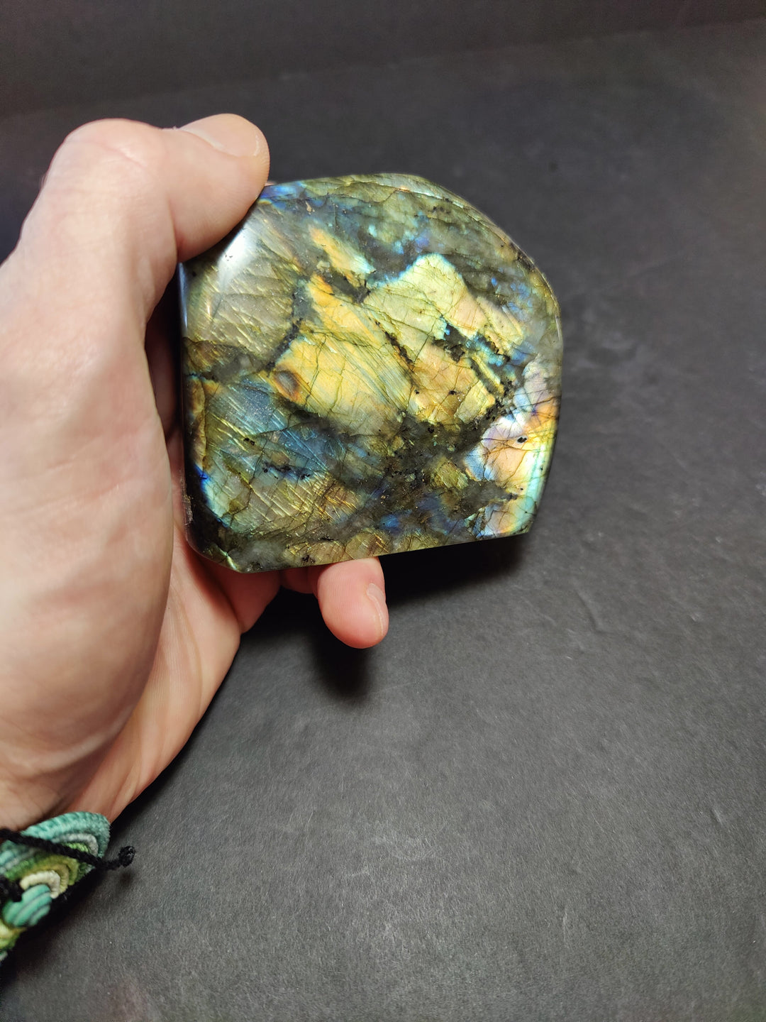 Polished labradorite freeform sculpture, yellow-gold with dark swirls and blue highlights