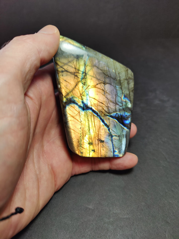 Polished labradorite freeform sculpture, golden tan with blue streaks and glassy shine