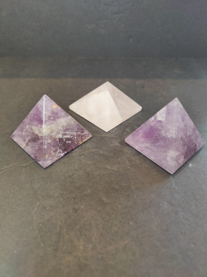 Assorted polished stone pyramid sculptures in lavender purple and white