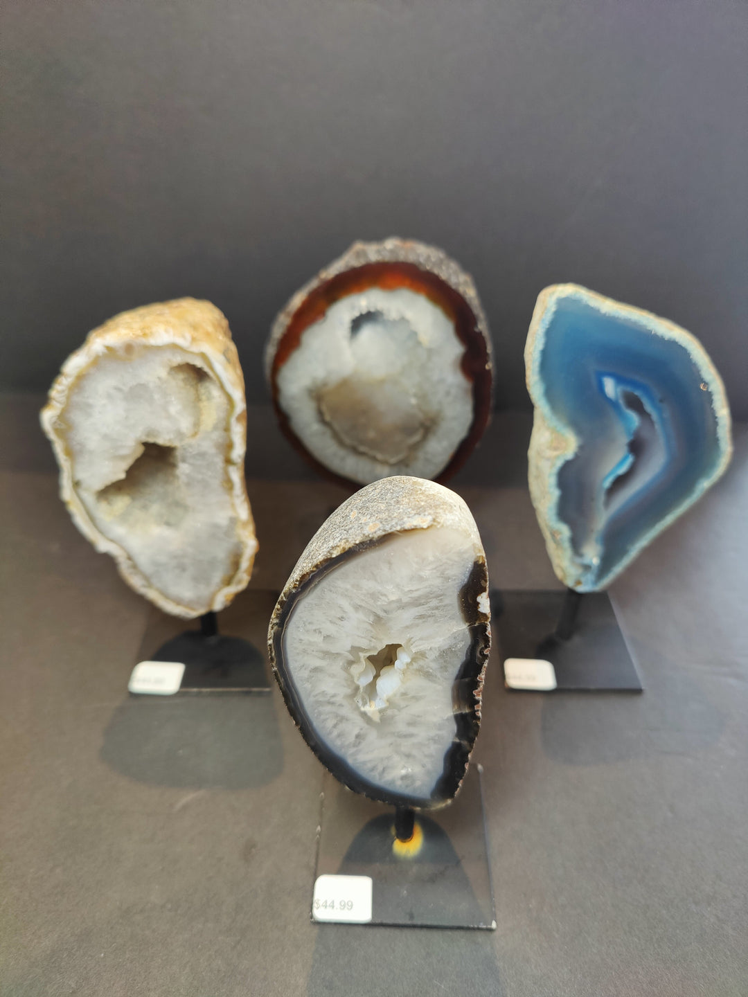 Polished agate geode slices on metal stands, one dark blue and white, rounded edges