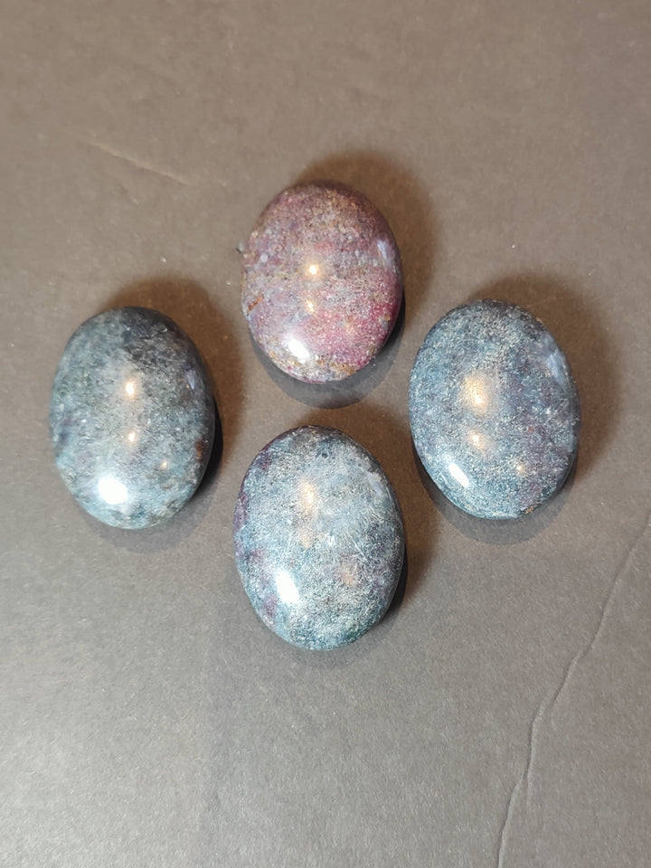 Polished ruby kyanite palmstones, smooth ovals with purple, pink, and blue shimmer