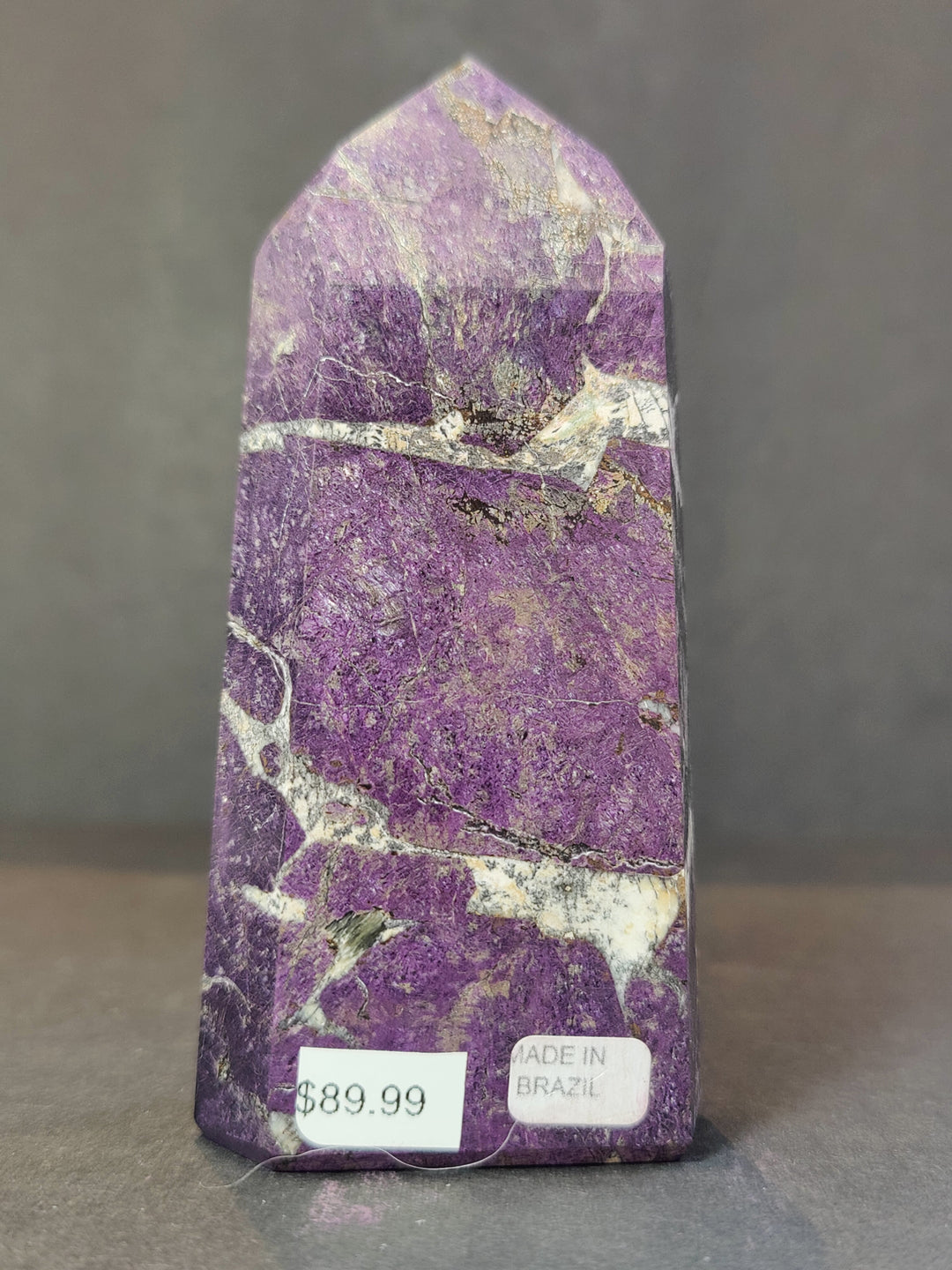 Polished purpurite obelisk tower sculpture, purple stone with prominent white banding.