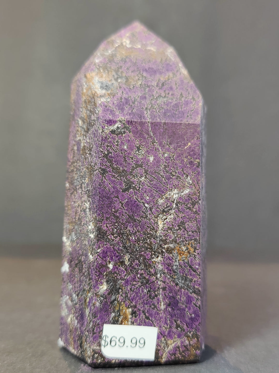 Polished purpurite obelisk tower sculpture, front view of vivid purple crystal.