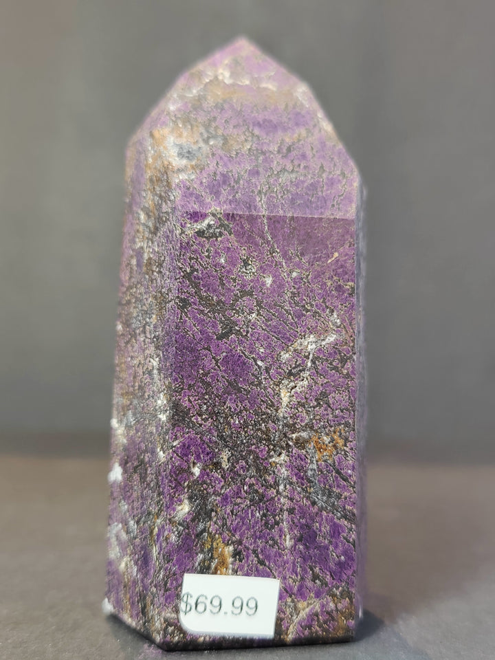 Polished purpurite obelisk tower sculpture, front view of vivid purple crystal.