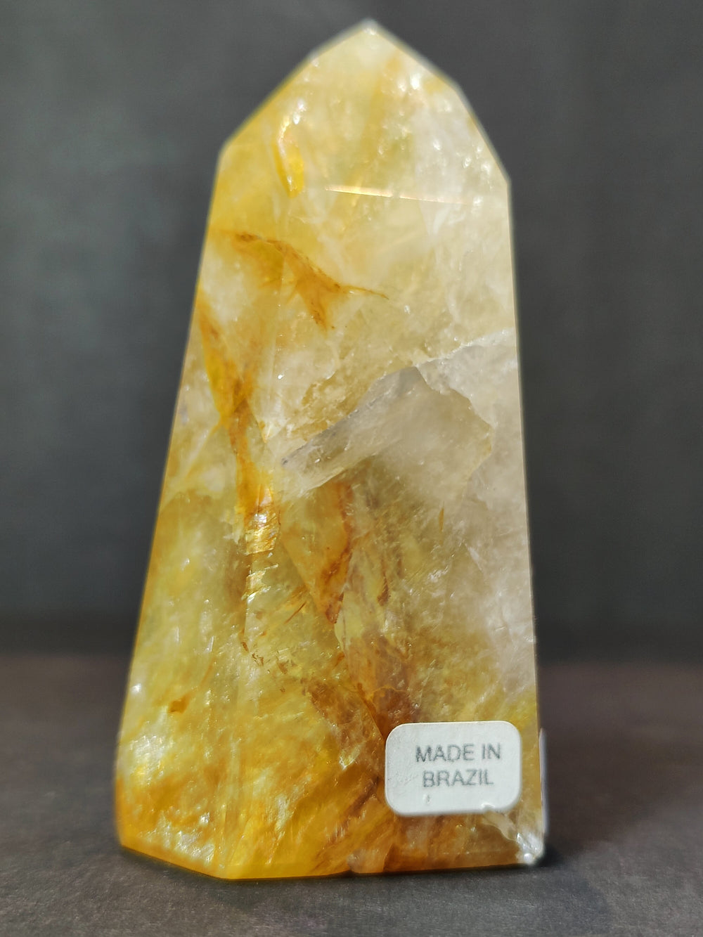 Single polished yellow quartz obelisk tower with faceted crystal texture