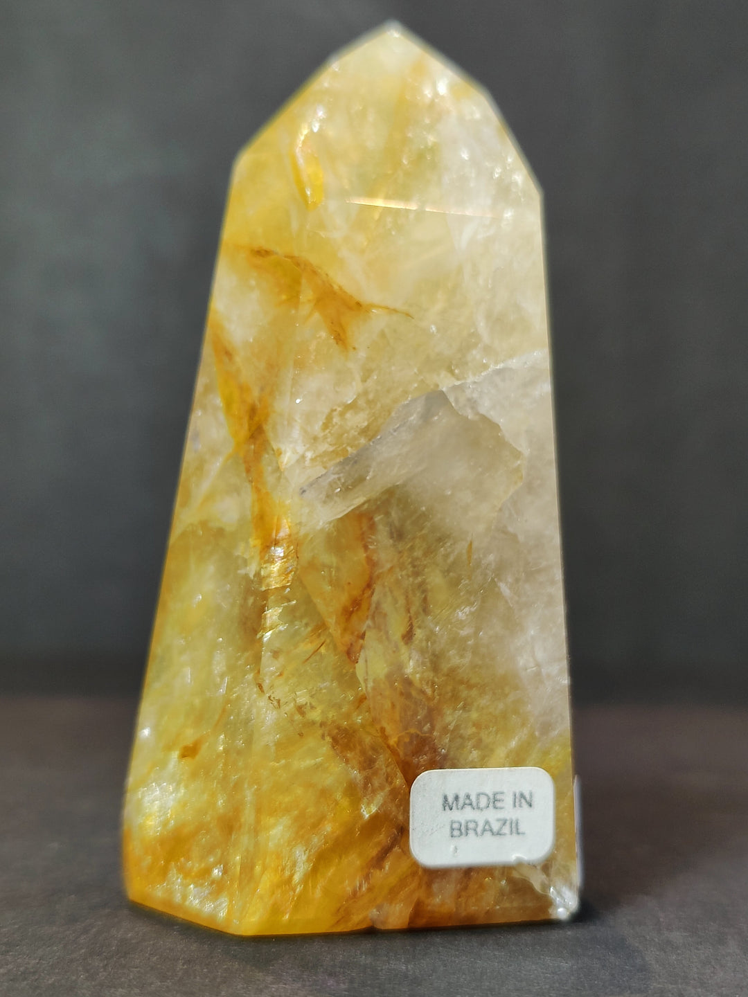 Single polished yellow quartz obelisk tower with faceted crystal texture