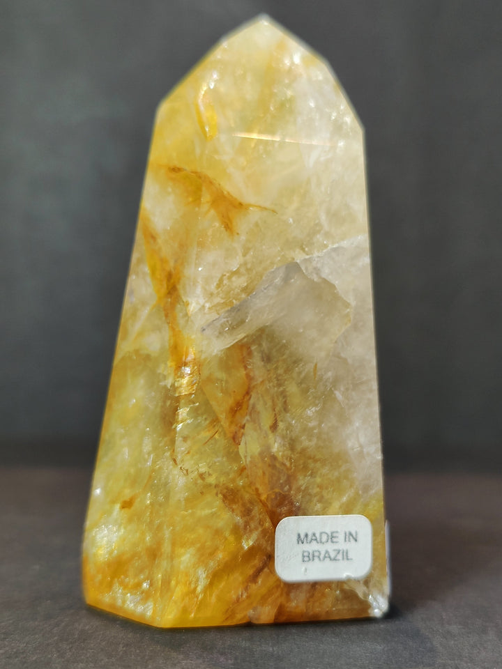 Single polished yellow quartz obelisk tower with faceted crystal texture