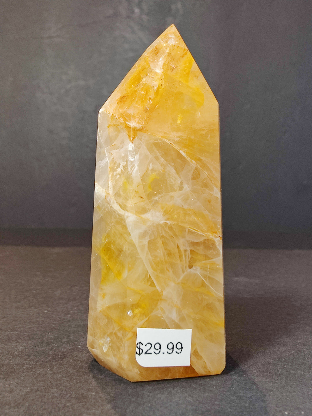 Polished yellow quartz obelisk tower sculpture with a pointed top