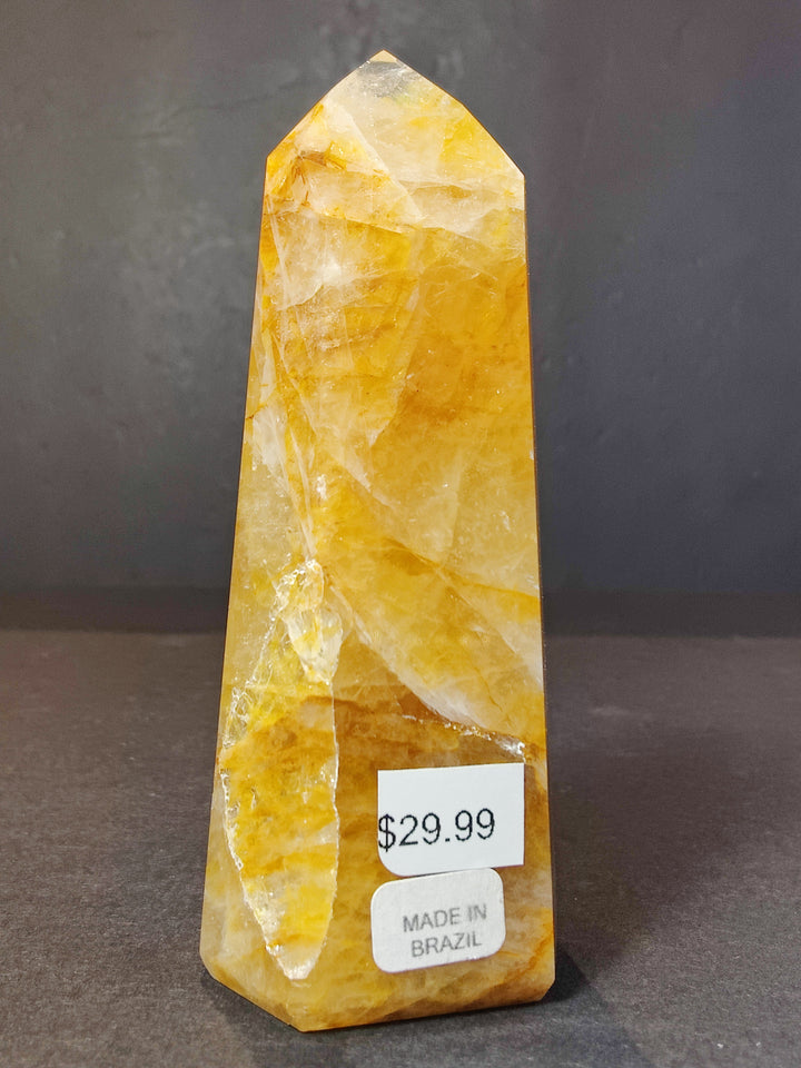 Polished bright yellow quartz obelisk tower sculpture with translucent facets