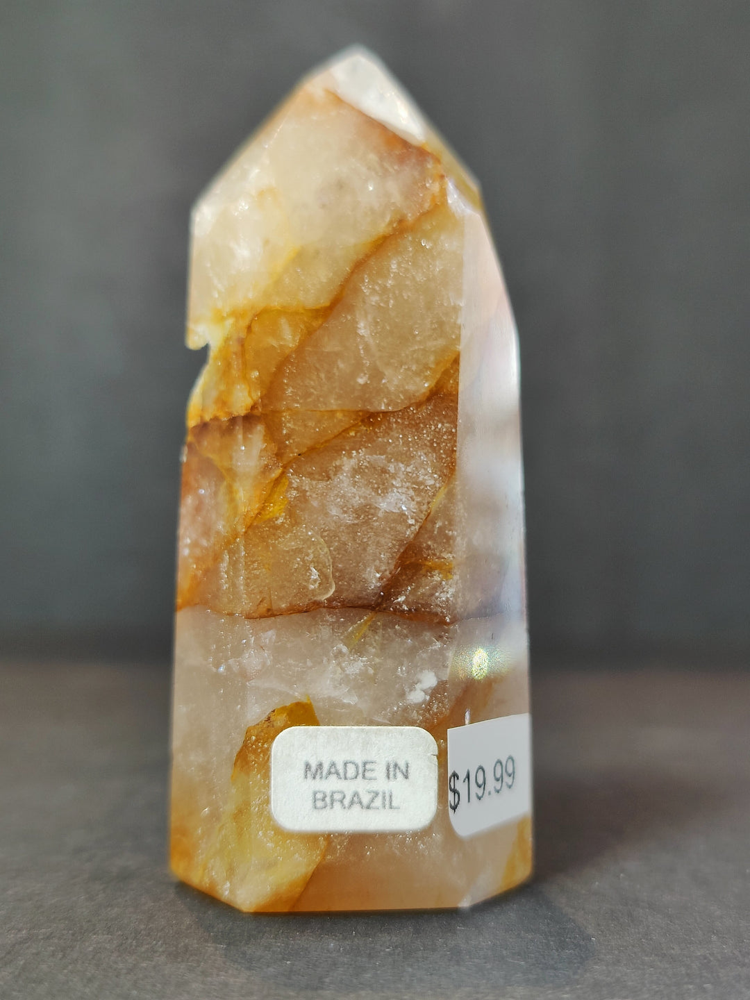 Polished white and orange quartz obelisk tower with layered crystal texture