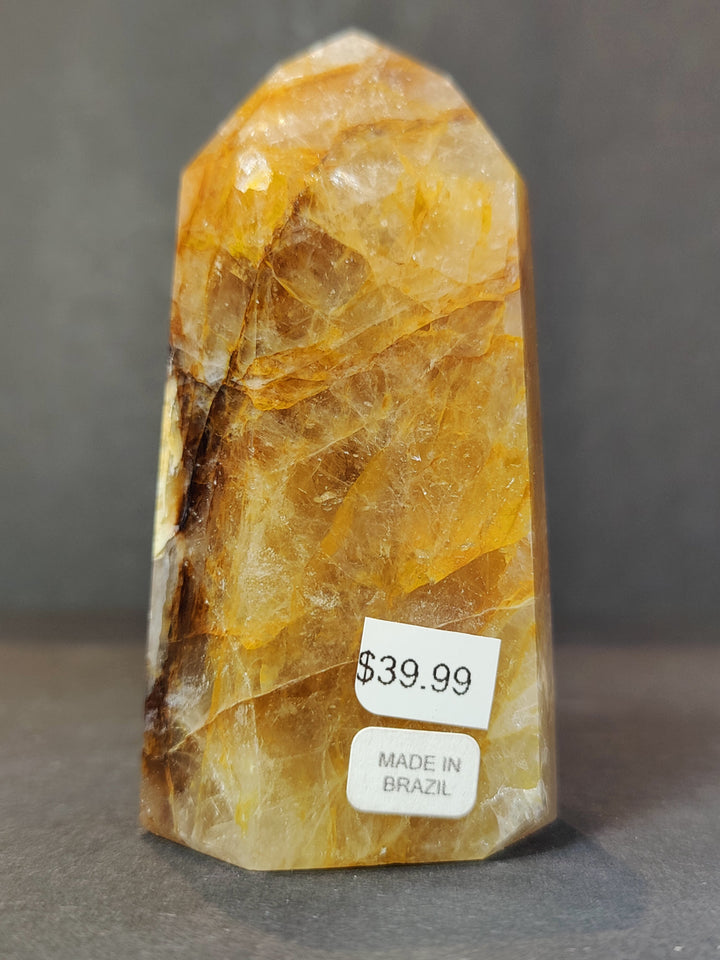 Polished golden quartz obelisk tower sculpture with dark streaking