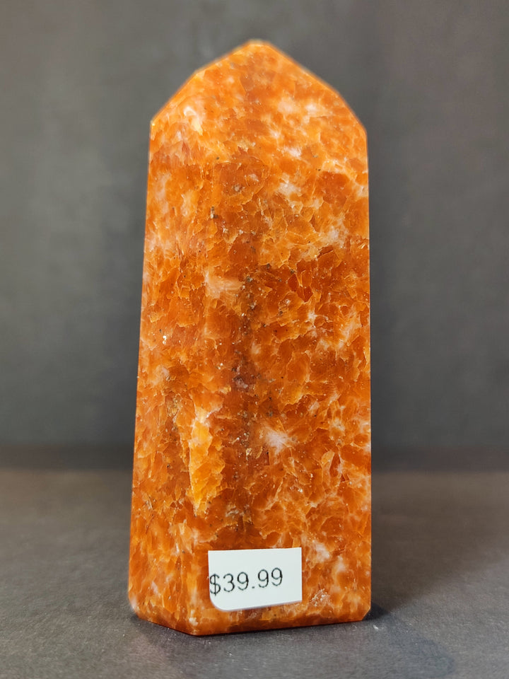 Polished sunstone obelisk tower sculpture, orange with glossy polished finish