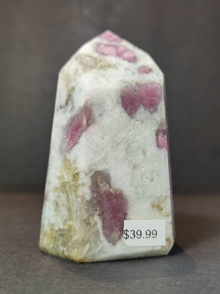 Polished quartz obelisk tower with pink patches and pale yellow-green tint areas
