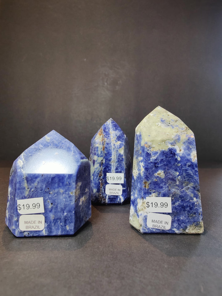 Polished blue sodalite obelisk towers, four-piece set with $19.99 tags.