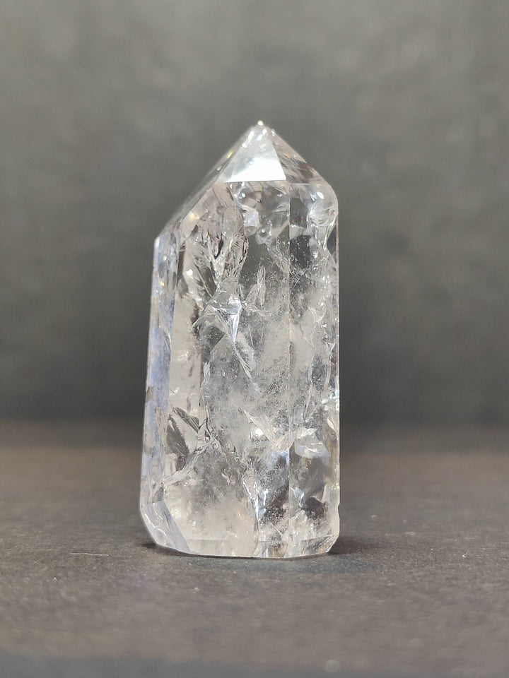 Single tall clear quartz point with faceted prism surfaces
