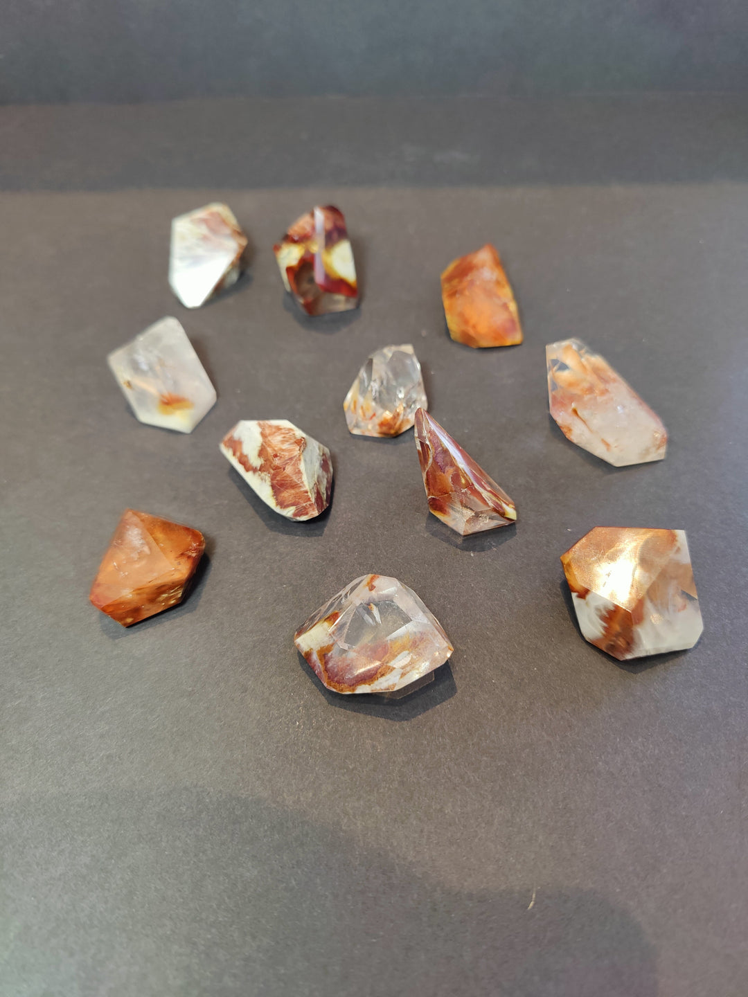 Polished freeform quartz crystal pieces, mixed orange, clear, and white facets.