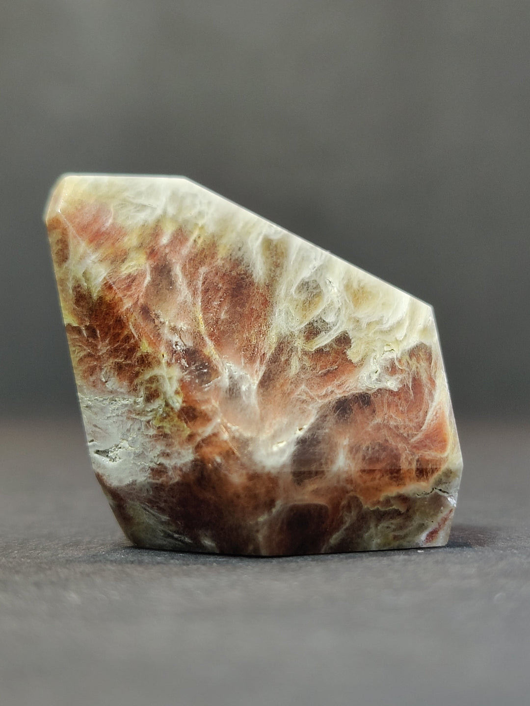 Polished freeform quartz crystal, white base with brown and orange cloudy veining.