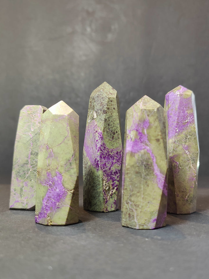 Polished crystal tower sculpture set, pale green with purple patches, faceted pointed tops