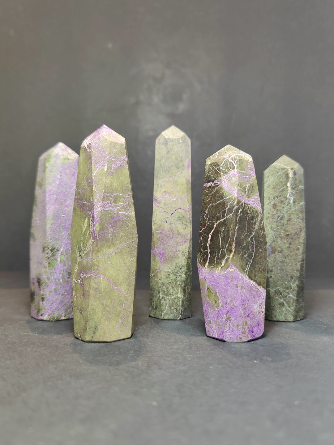 Polished crystal tower sculptures, pale green and lavender marbling, faceted pointed tops