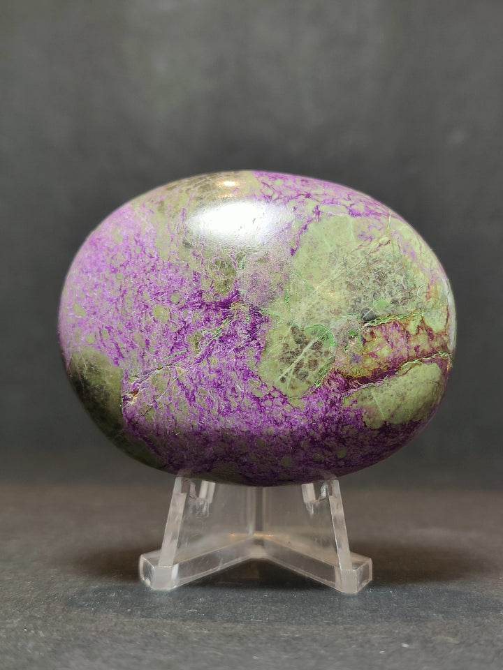 Polished purple and green gemstone palmstone sculpture on clear stand