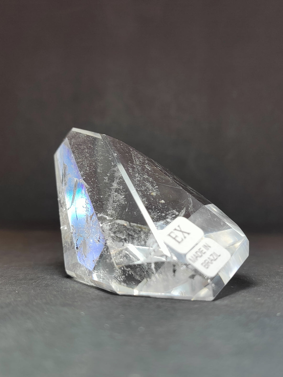 Clear quartz free-form crystal with smoky tones; EX label and iridescent color patch