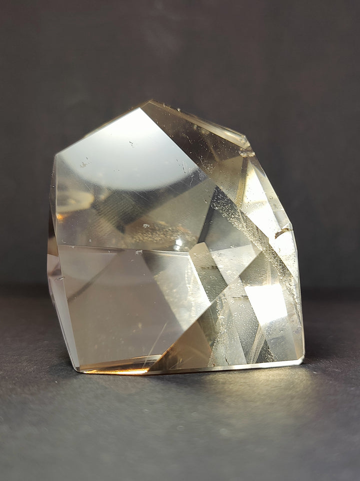 Clear quartz free-form sculpture with high-polish facets; label not visible