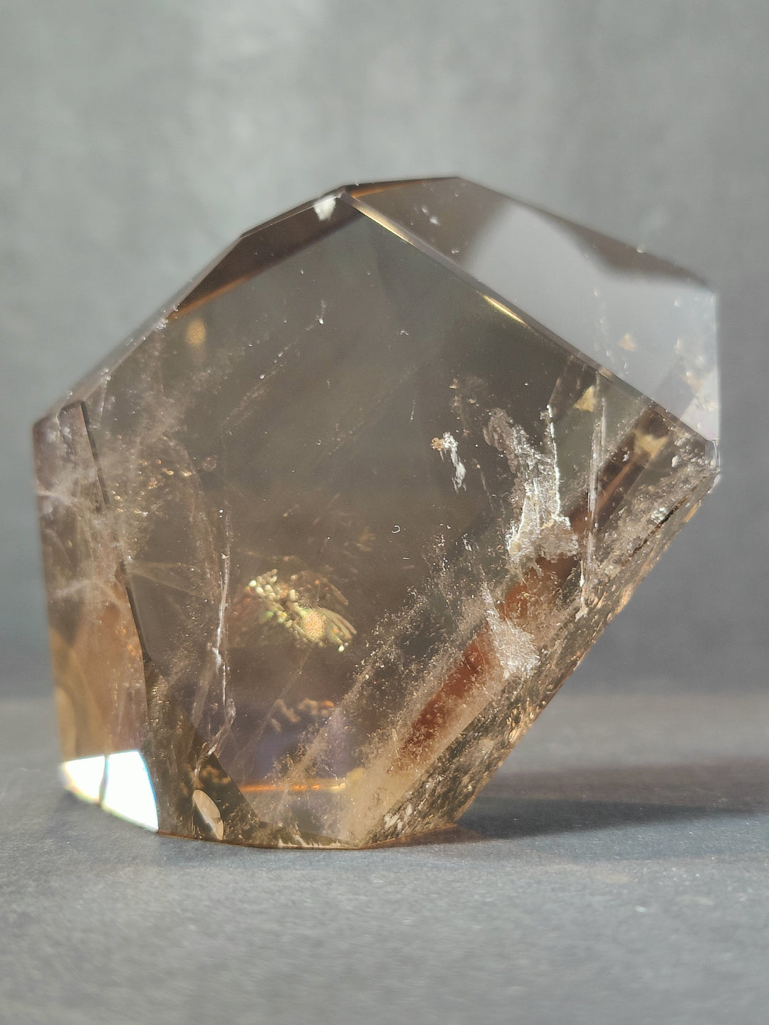 Clear smoky quartz free-form sculpture with glossy facets and internal veining
