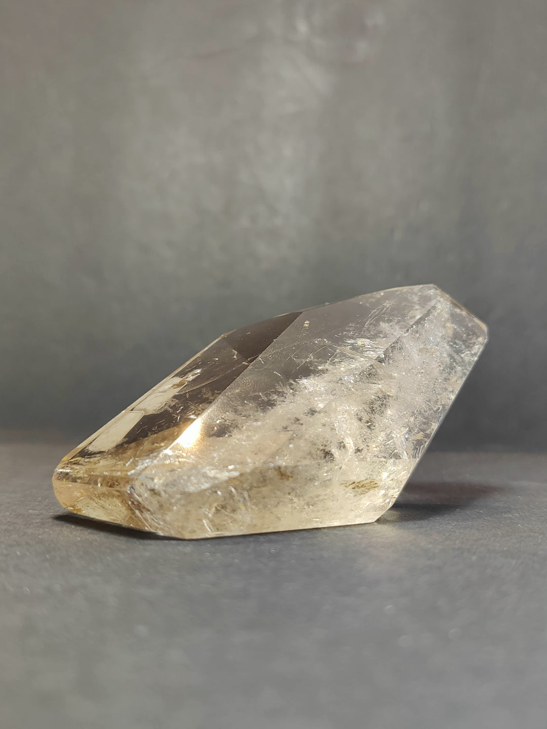 Smoky clear quartz free-form sculpture, long polished oblong shape with faceted edges