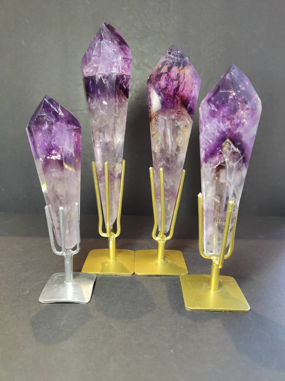 Set of amethyst crystal scepter wands on metal bases, purple and clear facets