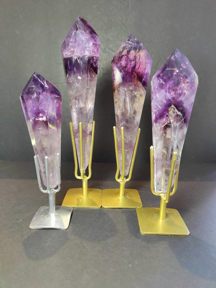 Set of amethyst crystal scepter wands on metal bases, purple and clear facets