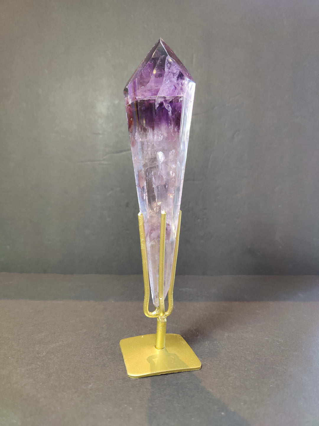 Single amethyst crystal scepter wand on gold metal stand, clear purple top