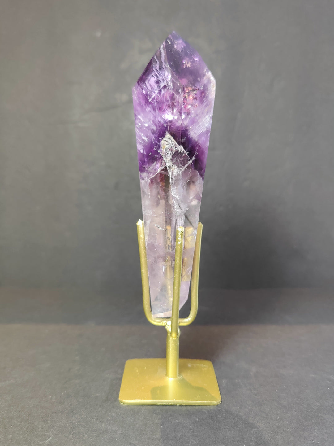 Single amethyst crystal scepter wand on gold metal stand, purple veined point