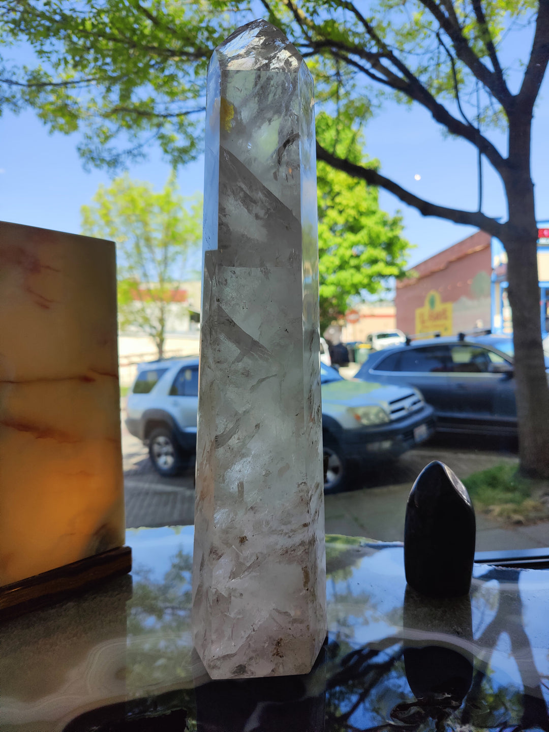 Polished clear quartz obelisk, tall faceted crystal with pointed top and clear body
