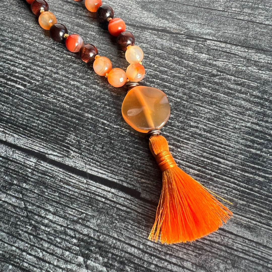 Orange and dark brown bead meditation mala with amber heart charm and orange tassel