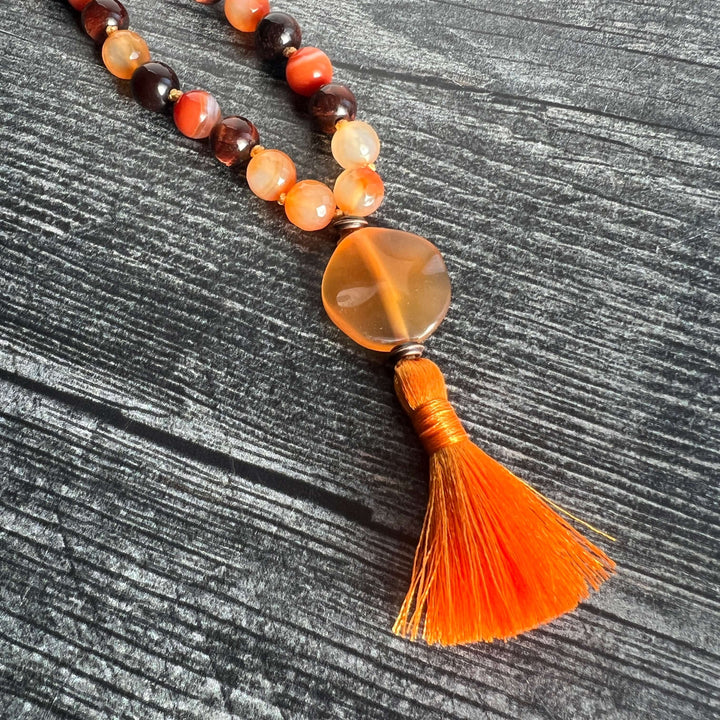 Orange and dark brown bead meditation mala with amber heart charm and orange tassel