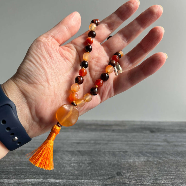 Orange and dark bead meditation mala with amber heart pendant and orange tassel