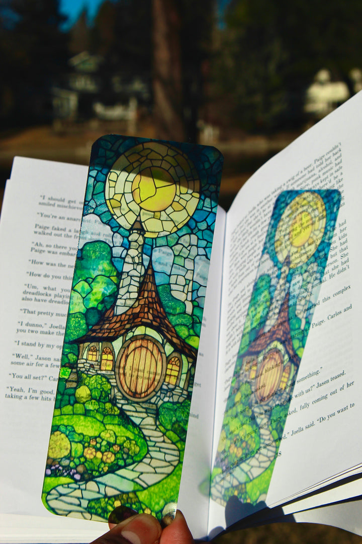 Stained-glass fantasy bookmark, blue and green, between open book pages