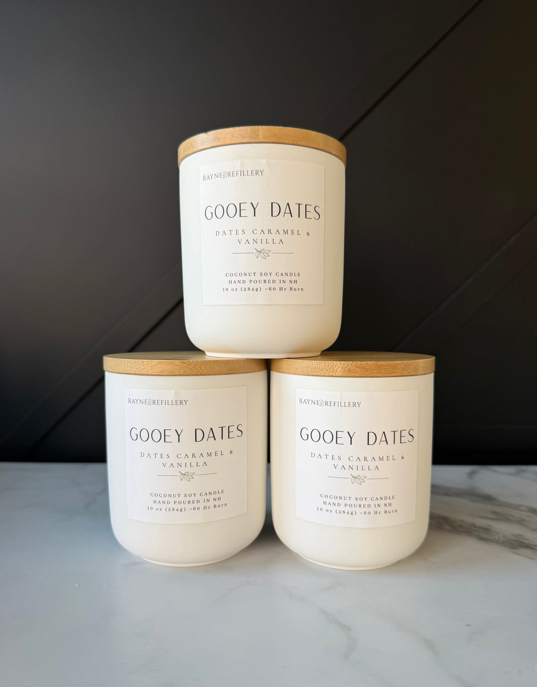 Set of three Gooey Dates vanilla coconut soy wax candles, white jars with tan lids.