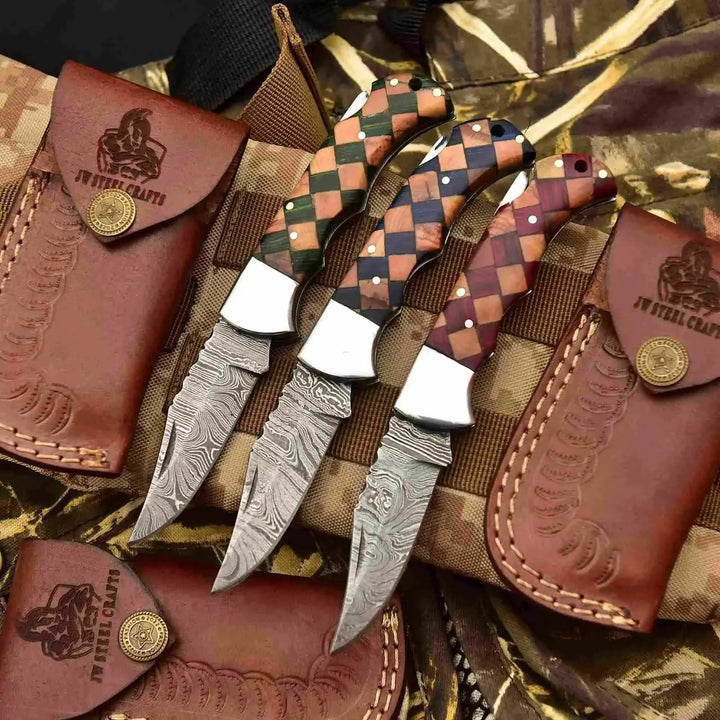 Damascus folding knife set with checkered handles and leather pouch