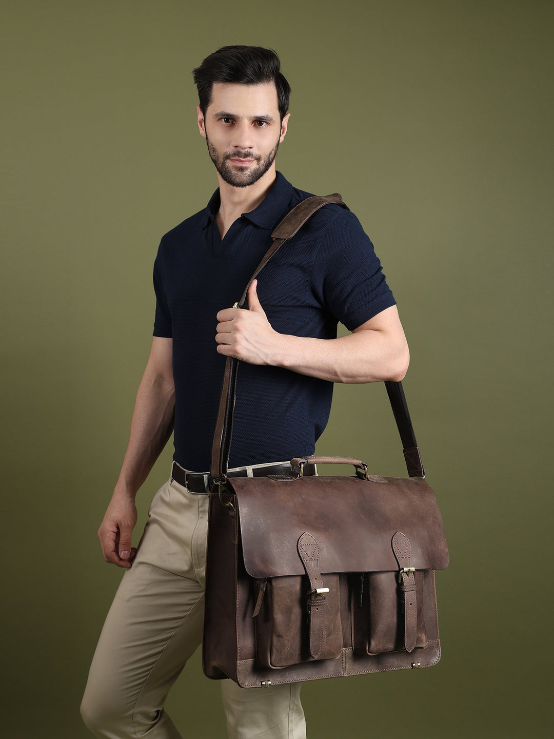 Brown leather messenger bag worn on shoulder with flap front and pocket details
