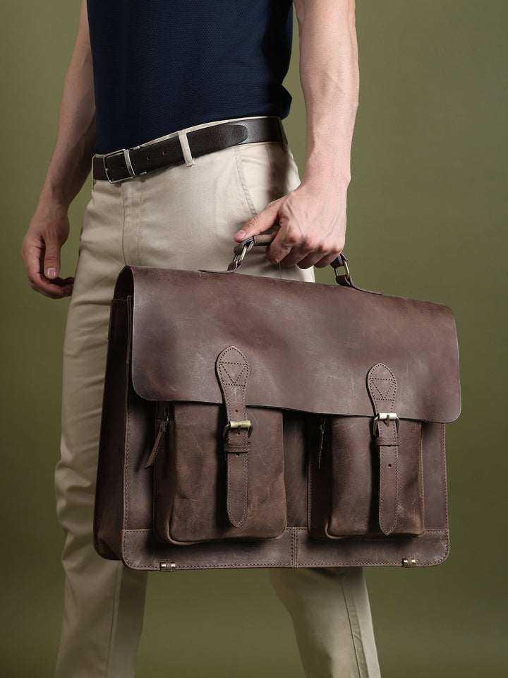 Brown leather messenger bag with adjustable shoulder strap and flap front storage pockets