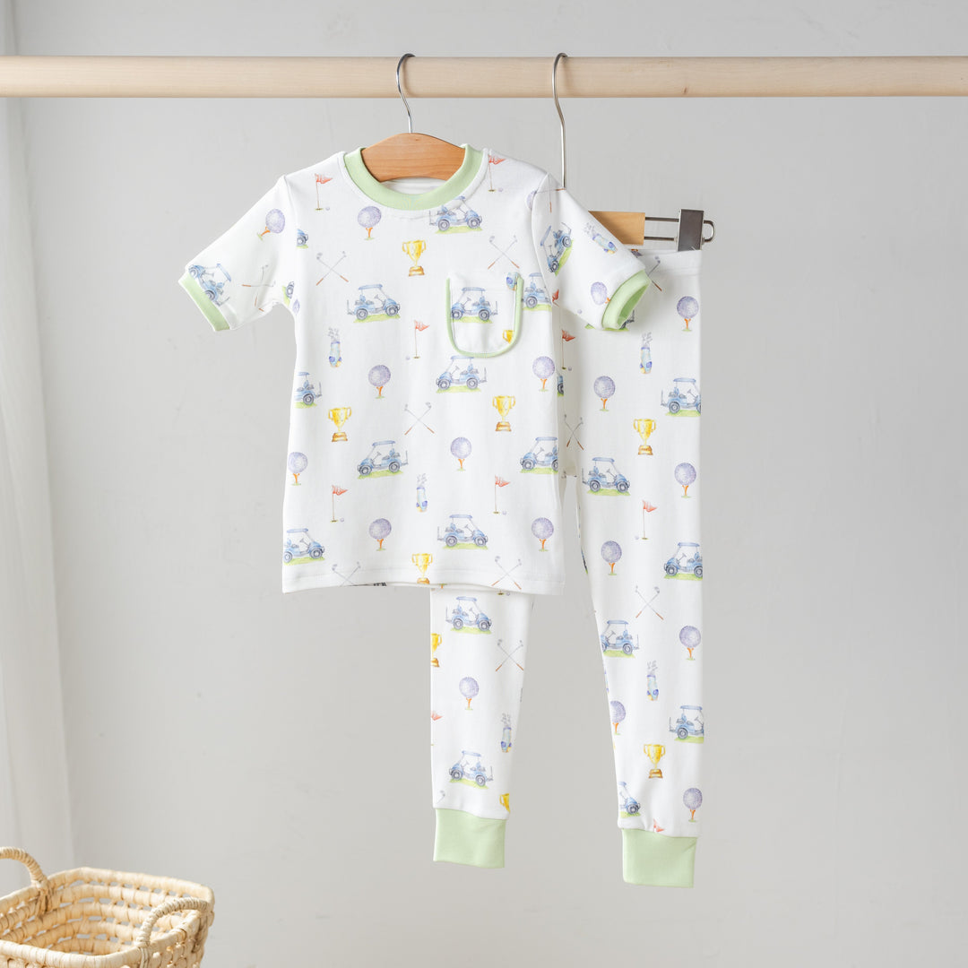 Hanging organic cotton pajama set, white long-sleeve top and pants with green cuffs