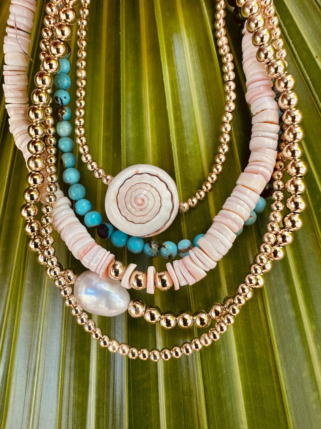 Gold-tone layered anklets with turquoise beads and white shell-disc accents