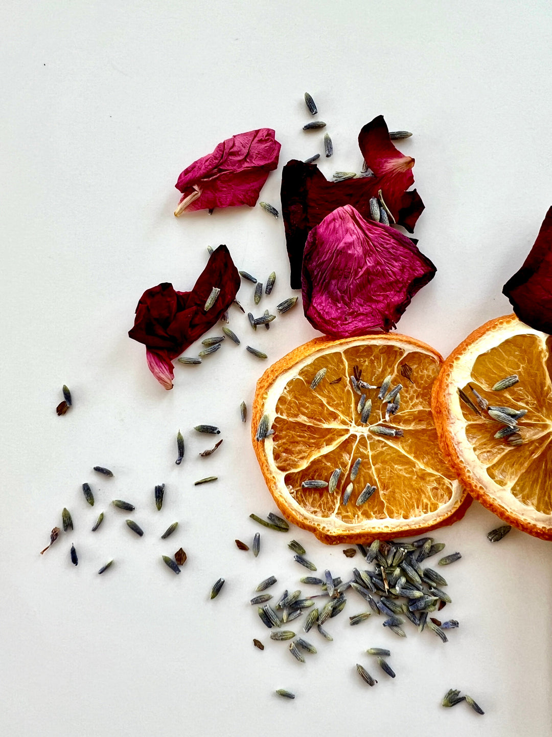 Dried orange slices with herb sprigs and dried flower petals for simmer pot