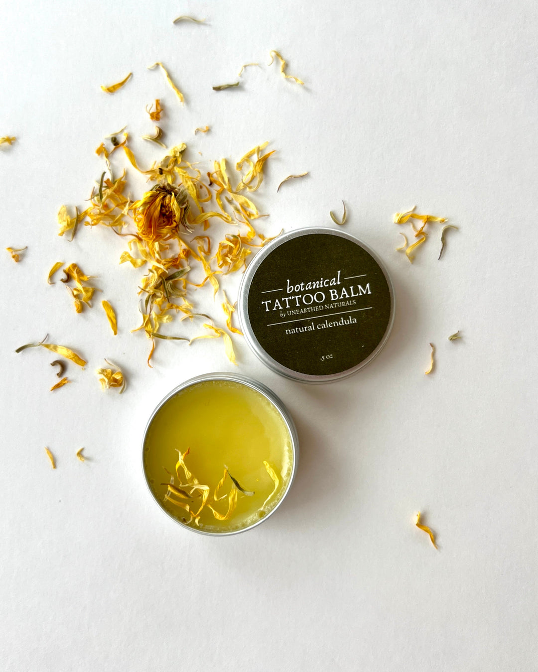 Two tattoo balm tins: yellow salve tin and natural calendula brown label tin