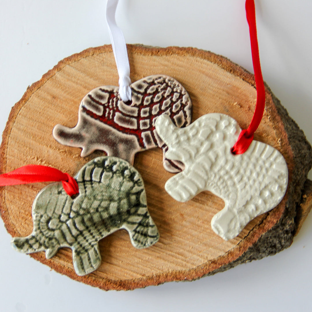 Set of three elephant ornaments in grey and white with red and white hanging ribbons