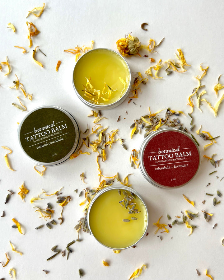 Tattoo balm tin with glossy yellow calendula salve and silver metal lid