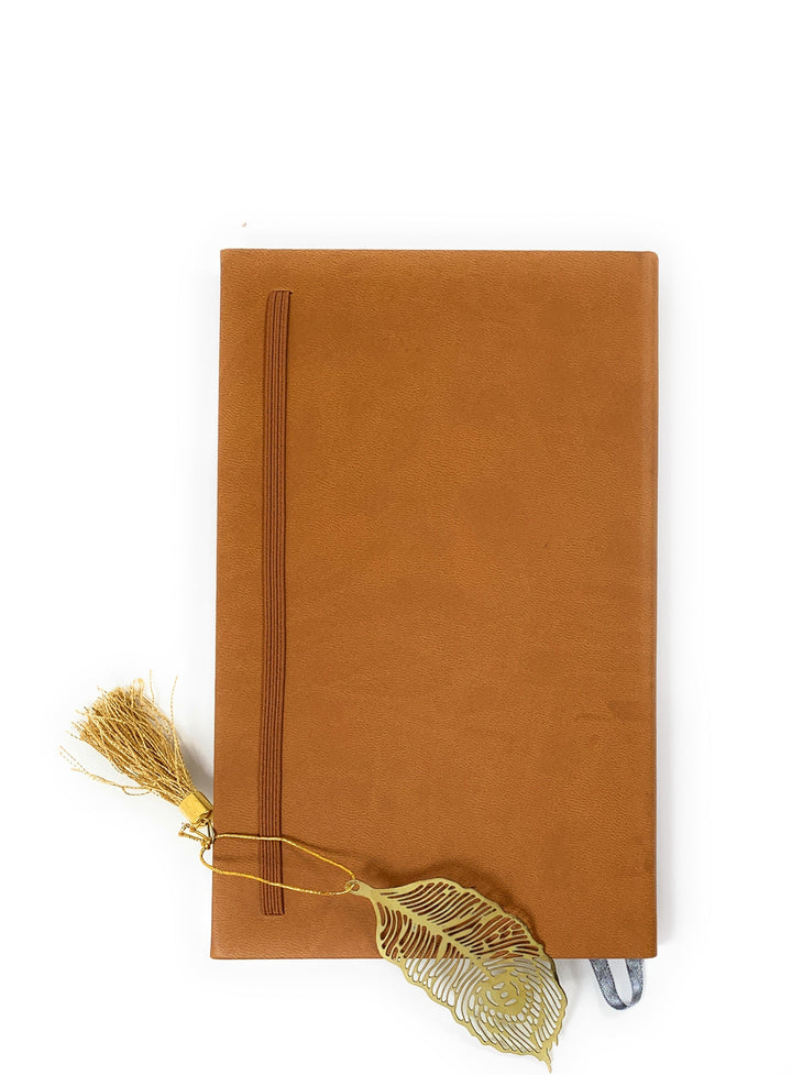 Feather bookmark with gold finish and tassel on brown notebook cover