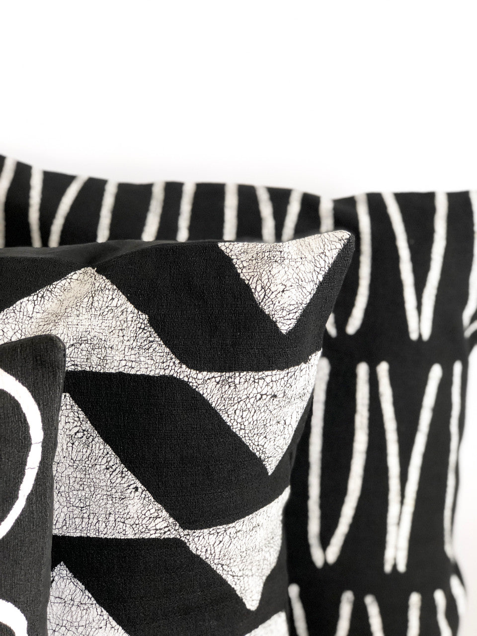 Close-up Sadza Triangles pillow cover showing black chevron triangles and silver texture