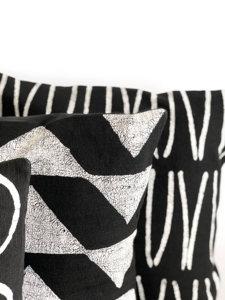 Close-up Sadza Triangles pillow cover showing black chevron triangles and silver texture